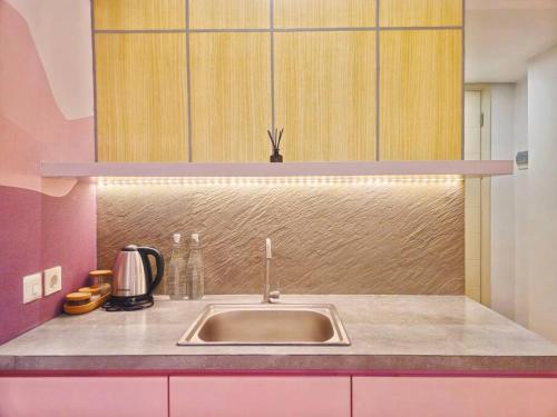 uma cozinha com um lavatório e uma bancada em Pinky Rose @Anderson Apartment em Surabaya