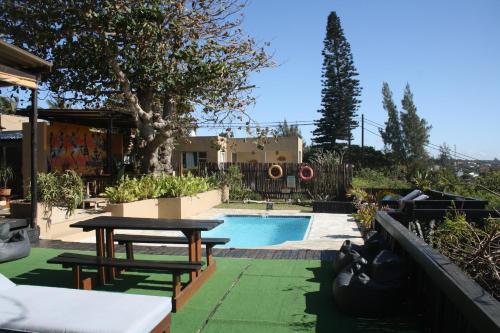 una piscina con mesa y bancos junto a ella en Planet Scuba Bed and Breakfast, en Ponta do Ouro