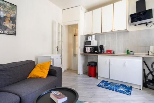 Il comprend un salon avec un canapé et une cuisine. dans l'établissement Cosy T2 à 5 minutes de Metro 12-Proche Paris-Stade de France, à Aubervilliers