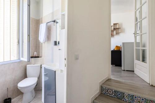 La salle de bains blanche est pourvue de toilettes et d'une fenêtre. dans l'établissement Cosy T2 à 5 minutes de Metro 12-Proche Paris-Stade de France, à Aubervilliers