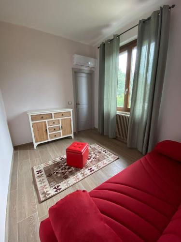 un salon avec un canapé rouge et une boîte rouge dans l'établissement Casa Vacanze la Pineta, à Montalcino