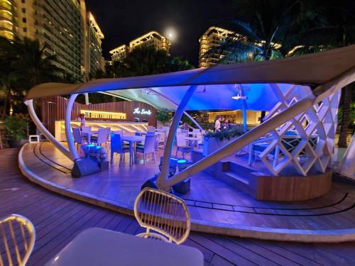 a table and chairs on a deck at night at AZURE URBAN RESIDENCES PARAÑAQUE by M&D Maui Tower in Manila