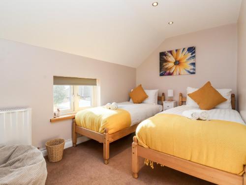 a bedroom with two beds and a window at 4 Lynton Cottages in Hull