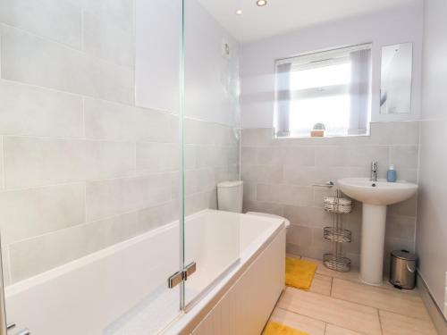 a white bathroom with a tub and a sink at 4 Lynton Cottages in Hull