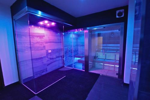 La salle de bains est pourvue d'une douche à l'italienne avec des lumières violettes. dans l'établissement Le Maginot Relais, 