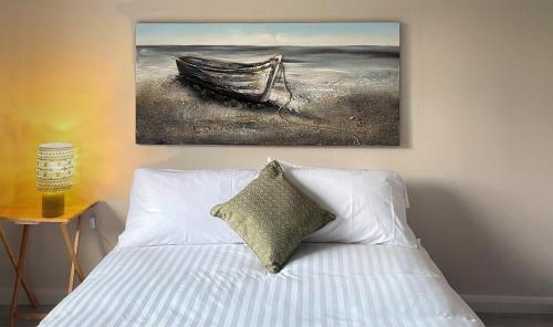 een slaapkamer met een bed met een schilderij aan de muur bij Donegal Town House in Donegal