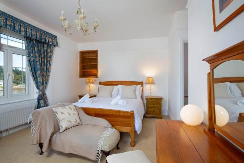 a bedroom with two beds and a chair at Cliff Cottage in Brixham