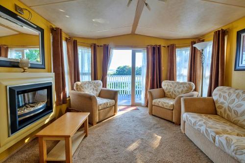 a living room with a couch and chairs and a fireplace at Finest Retreats - Ocean View in Porchfield