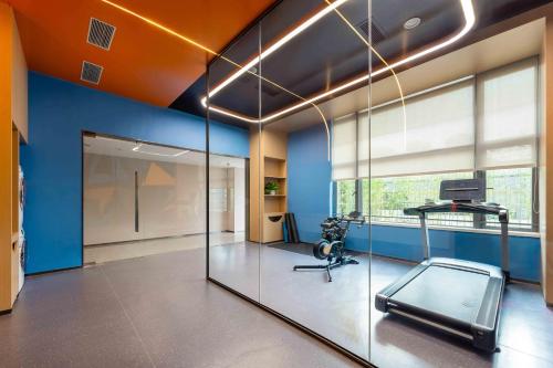 an office with a gym with a glass wall at Holiday Inn Express Jiangmen East Station by IHG in Jiangmen