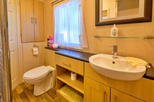 ein Badezimmer mit Waschbecken, Toilette und Spiegel in der Unterkunft Finest Retreats - Ocean View in Porchfield