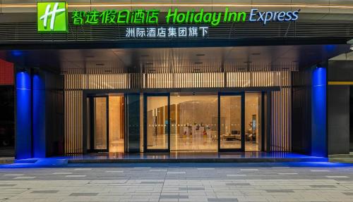 an entrance to a building with blue columns and windows at Holiday Inn Express Jiangmen East Station by IHG in Jiangmen