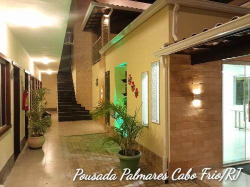 a hallway of a building with potted plants at Pousada Palmares in Cabo Frio