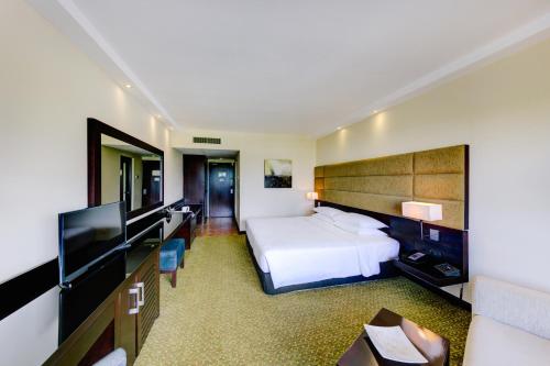 a hotel room with a bed and a flat screen tv at Cinnamon Lakeside in Colombo