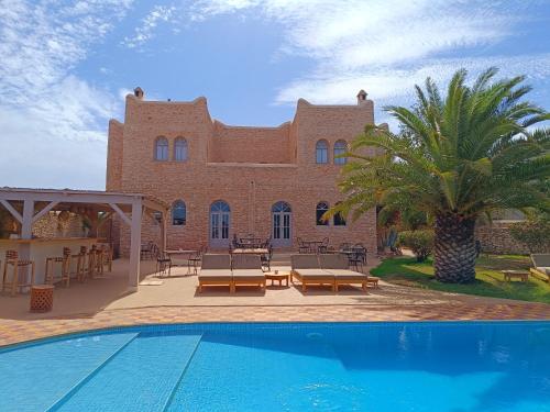 a house with a swimming pool in front of a building at Villa Maya in Essaouira