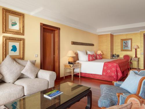 a hotel room with a bed and a couch at Hotel Botanico y Oriental Spa Garden in Puerto de la Cruz