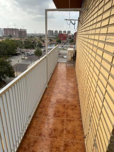 einen Balkon mit einem weißen Zaun und einer Ziegelwand in der Unterkunft Habitacion K&K in Valencia