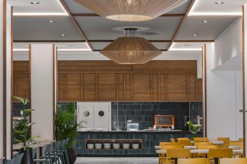 comedor con sillas amarillas y techo en FERGUS Puerto de la Cruz, en Puerto de la Cruz