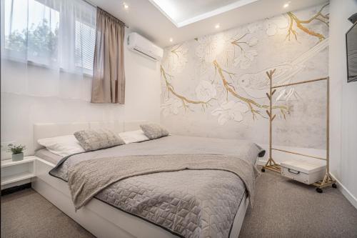 a bedroom with a bed and a wall with flowers at Apartments By Pyramid: Elisabeth in Bratislava