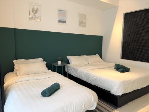 two beds in a room with green and white at KASOTA SUITE Aeropod Sovo-Near KKCity-Near Airport in Tanjong Aru