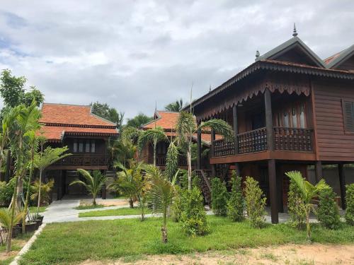 a building withtropical architecture with trees and plants at Apsara Khmer House in Siem Reap