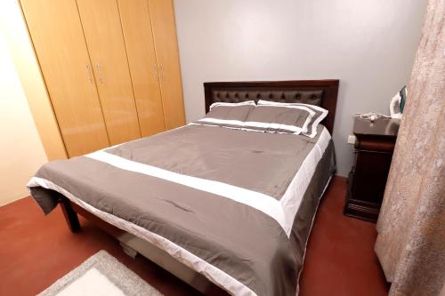 a bedroom with a large bed with a wooden headboard at Cossy homes in Nakuru