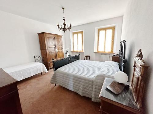 a bedroom with two beds and a table and windows at Casale di Valle Mora in San Gimignano