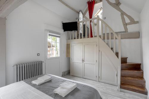 ein weißes Zimmer mit einem Bett und einer Treppe in der Unterkunft Chambres d'hôte - Clos d'Allonne in Beauvais