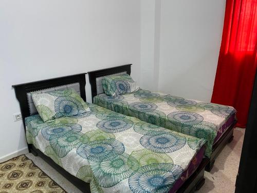dwa łóżka siedzące obok siebie w pokoju w obiekcie Karim DUPLEX w mieście Nabul