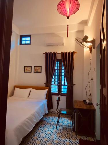 a bedroom with a white bed and a pink umbrella at SEVEN HOMESTAY(HUE) in Hue
