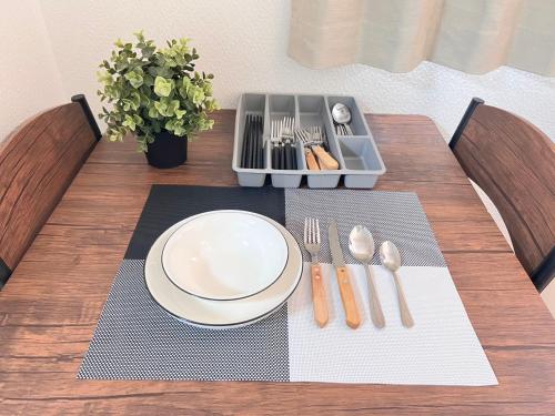 een tafel met een bord en lepel en vork en mes bij 大阪旅・四葉　 in Osaka