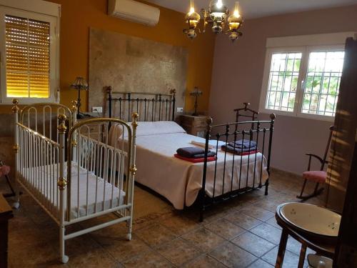 a bedroom with two beds and a table and windows at Villa en la Vega del pueblo in Cantoria