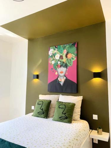 a bedroom with a bed with a painting on the wall at L'escale Béthunoise - Maison duplex, hyper-centre in Béthune