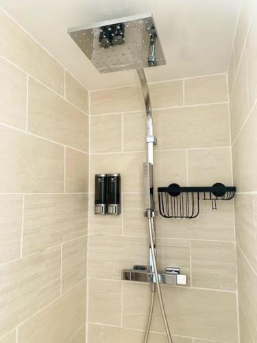 a shower with a shower head in a bathroom at L'escale Béthunoise - Maison duplex, hyper-centre in Béthune