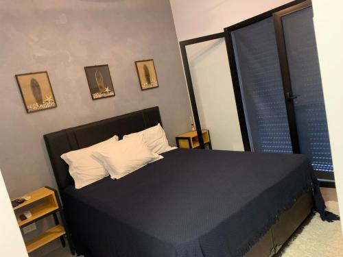 Un dormitorio con una cama negra con almohadas y ventanas en Casa térrea com acessibilidade em Juquehy com piscina aquecida e hidromassagem, en Juquei