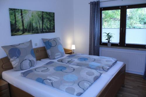 1 dormitorio con 1 cama con almohadas azules y grises en Ferienwohnung Sauerland Feeling, en Olsberg