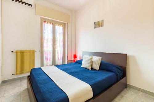 1 dormitorio con cama con sábanas azules y ventana en Appartamento L'Approdo - MyHo Casa, en Vasto