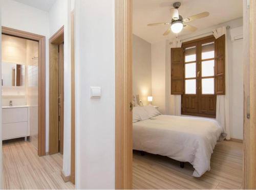 um quarto com uma cama branca e uma casa de banho em Mexüar Homes Navas em Granada