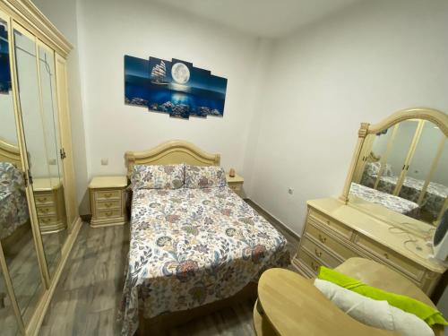 een slaapkamer met een bed, een ladekast en een spiegel bij House in Malaga in Málaga