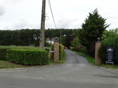 uma estrada vazia com um poste de telefone e arbustos em Le domaine du château blanc à 10 minutes de Paira Daiza em Jurbise