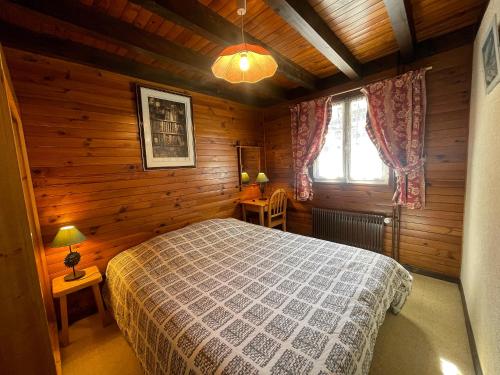 Un dormitorio con una cama en una cabaña de madera. en Cotterg - Chalet individuel 15 pers, centre village et proches pistes de ski, en La Clusaz