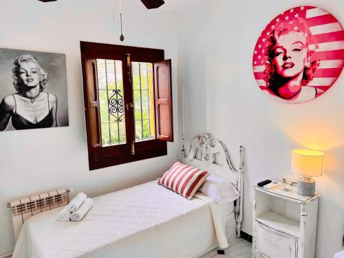 a white bedroom with a bed and a window at Hotelito Suecia in Granada