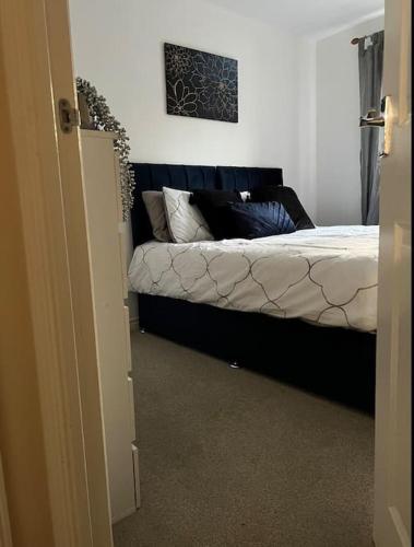 ein Schlafzimmer mit einem Bett mit einem Sofa darin in der Unterkunft Cozy 2bed apartment w/ parking in Swindon
