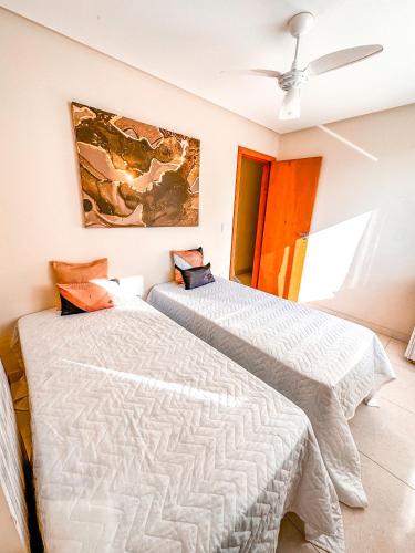 1 dormitorio con 2 camas y ventilador de techo en Apt na Praia do Morro,2 quadras do mar,com Garagem, en Guarapari