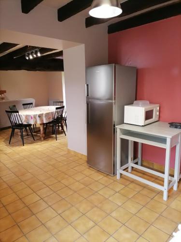 Il comprend une cuisine équipée d'un réfrigérateur et d'une table avec un four micro-ondes. dans l'établissement Maison à la campagne 