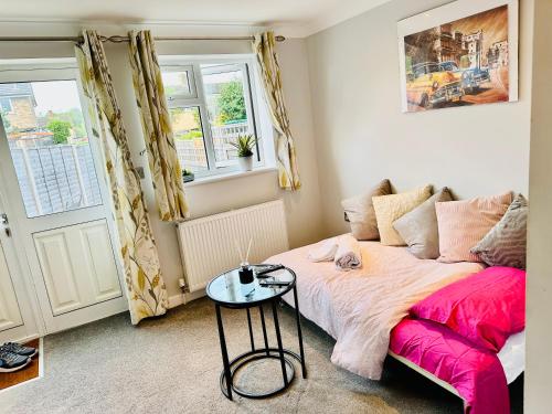 a bedroom with a bed and a table at Cozy Bicester Village townhouse with garden in Bicester