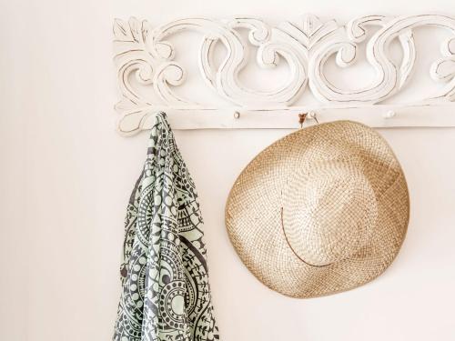 a straw hat and a bag hanging on a wall at Paradise Design Apartments in Batsi
