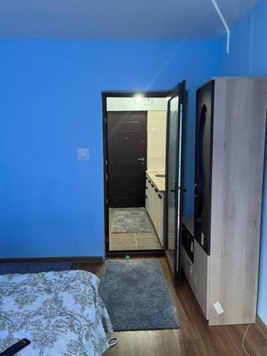 Cette chambre est dotée d'un mur bleu, d'un lit et d'un miroir. dans l'établissement MEHTUP SRL, à Piteşti