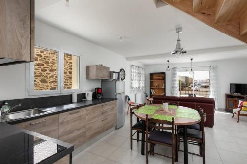 une cuisine avec une table et des chaises dans une cuisine dans l'établissement Maison neuve au centre-ville proche de l'aéroport, à Guipavas