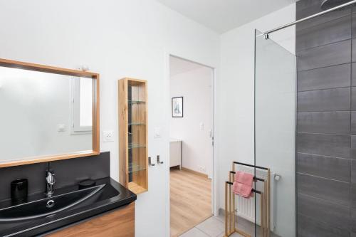 a bathroom with a sink and a glass shower at Maison neuve au centre-ville proche de l'aéroport in Guipavas