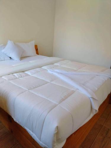 a large white bed sitting in a room at Hotel Bandipur Bisauni in Bandipur